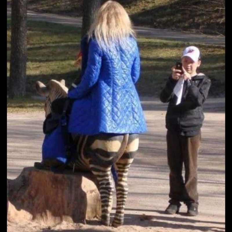 woman sitting on animal that looks like pants